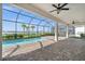 Covered patio area with brick pavers, serene water view, ceiling fans, and an inviting pool at 42346 Waterfront Way, Punta Gorda, FL 33982