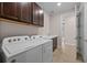 Well-lit laundry room features a Whirlpool washer and dryer, upper cabinets, and sink at 42346 Waterfront Way, Punta Gorda, FL 33982