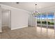 Spacious living room featuring a modern chandelier and sliding glass doors to the pool area at 42346 Waterfront Way, Punta Gorda, FL 33982