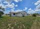 View of the home's back exterior with a spacious yard, offering privacy and room for outdoor activities at 4424 Baroda Ave, North Port, FL 34287