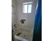 Bathroom with white tiled walls, shower head and curtain and window at 4424 Baroda Ave, North Port, FL 34287