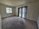 Bedroom featuring neutral walls, carpeted floors, curtains and view through the glass sliding door at 4424 Baroda Ave, North Port, FL 34287