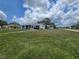Charming single-story home with a vibrant blue accent and a spacious front yard under a sunny sky at 4424 Baroda Ave, North Port, FL 34287