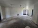 Spacious living room with neutral walls, drop ceiling with lights and picture window with curtains at 4424 Baroda Ave, North Port, FL 34287