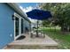 Backyard deck featuring a picnic table and a large blue umbrella for shade, perfect for outdoor dining at 4583 S Salford Blvd, North Port, FL 34287