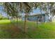 Fenced backyard with a well-maintained lawn, mature trees, and a cozy patio area with outdoor furniture at 4583 S Salford Blvd, North Port, FL 34287