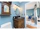 Bathroom with decorative wood vanity, mirror, and blue walls at 4583 S Salford Blvd, North Port, FL 34287