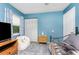 Bedroom with a cozy seating area, white closet doors and blue walls at 4583 S Salford Blvd, North Port, FL 34287