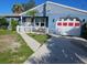 Quaint single-story blue house with a red and white garage door and a white picket fence at 4583 S Salford Blvd, North Port, FL 34287