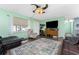 Cozy living room featuring hardwood floors, a ceiling fan, and a flatscreen television on a wooden cabinet at 4583 S Salford Blvd, North Port, FL 34287