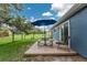 Backyard patio featuring a wooden deck with a table, bench, chair, and a view of the grassy lawn at 4583 S Salford Blvd, North Port, FL 34287