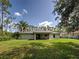 Lush backyard with manicured lawn, mature trees, and a view of neighboring properties, offering a peaceful outdoor space at 4609 Jaslo Ave, North Port, FL 34286