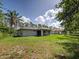 A spacious backyard features a lush lawn and mature trees, creating a private outdoor retreat at 4609 Jaslo Ave, North Port, FL 34286