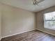 A bright bedroom with neutral walls and a modern ceiling fan with wood-look laminate flooring at 4609 Jaslo Ave, North Port, FL 34286