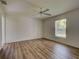 Bright bedroom with wood-look floors, ceiling fan, and a view of the yard through the window at 4609 Jaslo Ave, North Port, FL 34286