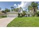 Charming single-story home boasts a lush green lawn and attached two-car garage with beautiful landscaping at 4609 Jaslo Ave, North Port, FL 34286