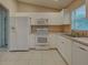 Bright kitchen with white appliances and light-colored counters at 4609 Jaslo Ave, North Port, FL 34286