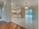 Bright kitchen with white cabinets, tile floor, and sliding glass doors to the patio at 4609 Jaslo Ave, North Port, FL 34286