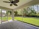 View of the covered patio and backyard, featuring a ceiling fan and screened enclosure at 4609 Jaslo Ave, North Port, FL 34286
