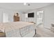 The primary bedroom with ensuite bathroom features neutral walls, plush carpet, and a large TV for relaxing comfort at 5436 Jessamine Ave, North Port, FL 34291