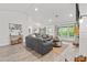 Open-concept living space with wood-look flooring, large windows, and neutral decor at 5436 Jessamine Ave, North Port, FL 34291