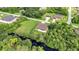 An aerial view shows the property surrounded by trees and the surrounding neighborhood at 5451 Prime Ter, North Port, FL 34286