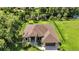 An aerial view showcases a modern home with lush greenery, complemented by a two-car garage at 5451 Prime Ter, North Port, FL 34286