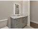 Modern bathroom vanity featuring gray cabinetry, marble countertop, undermount sink, and illuminated mirror at 5451 Prime Ter, North Port, FL 34286