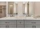 Bathroom featuring double sinks with marble countertops, gray cabinetry, and framed mirrors with lighting at 5451 Prime Ter, North Port, FL 34286
