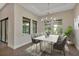 Elegant dining room with a modern chandelier, marble table, and large windows offering a serene view at 5451 Prime Ter, North Port, FL 34286