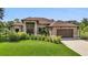 A charming single-story home boasts manicured landscaping and a two-car garage at 5451 Prime Ter, North Port, FL 34286