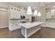Bright kitchen featuring white cabinets, stainless steel appliances, and a marble-topped island with pendant lighting at 5451 Prime Ter, North Port, FL 34286