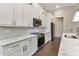 Gourmet kitchen featuring stainless steel appliances, white cabinetry, and a marble countertop at 5451 Prime Ter, North Port, FL 34286