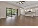 Spacious living room featuring an adjacent kitchen, a tray ceiling, and sliding glass doors to a screened patio at 5451 Prime Ter, North Port, FL 34286