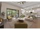 Open-concept living room featuring an adjacent kitchen, a tray ceiling, and sliding glass doors to a screened patio at 5451 Prime Ter, North Port, FL 34286