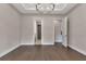 Neutral room featuring hardwood floors, neutral walls, a modern chandelier, and access to multiple rooms at 5451 Prime Ter, North Port, FL 34286