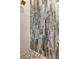 Bathroom shower featuring stylish stone pebble flooring and eye-catching wood grain-patterned wall tile at 5451 Prime Ter, North Port, FL 34286