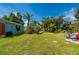 Lush backyard with well-maintained lawn, tropical plants, shed, and patio area perfect for outdoor enjoyment at 611 Bonita Ct, Punta Gorda, FL 33950