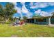 The vast backyard has a patio with a cozy sitting area, a screened-in porch, and beautiful tropical landscaping at 611 Bonita Ct, Punta Gorda, FL 33950