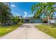 Charming single-story home with blue exterior paint, a driveway, and lush tropical landscaping at 611 Bonita Ct, Punta Gorda, FL 33950