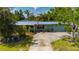 Well-maintained home featuring a metal roof, mature landscaping, and a neatly manicured lawn for enhanced curb appeal at 611 Bonita Ct, Punta Gorda, FL 33950