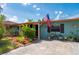 A charming home with a colorful facade and beautifully landscaped front yard with a quaint seating area at 611 Bonita Ct, Punta Gorda, FL 33950