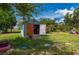 Charming shed with open doors, surrounded by a lush green lawn and tropical landscaping, offering ample storage space at 611 Bonita Ct, Punta Gorda, FL 33950