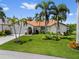 Inviting home featuring lush landscaping, mature palm trees, and a welcoming front entrance with lovely curb appeal at 632 Brindisi Ct, Punta Gorda, FL 33950