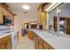Kitchen with white countertops and wooden cabinetry, with an open view to the living room and pool at 632 Brindisi Ct, Punta Gorda, FL 33950