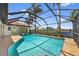 Sparkling screened pool surrounded by lush landscaping and canal views at 632 Brindisi Ct, Punta Gorda, FL 33950