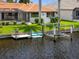 Waterfront property showcasing a private dock and boat lift, with lush landscaping at 632 Brindisi Ct, Punta Gorda, FL 33950