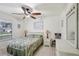 Bright bedroom with neutral walls, tiled floors, a ceiling fan, and a tropical themed comforter at 6764 Stardust Ave, North Port, FL 34287