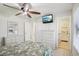 Well-lit bedroom with light walls, tile flooring, ceiling fan, and ensuite bathroom access at 6764 Stardust Ave, North Port, FL 34287