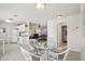 Open-concept dining area with tile flooring, a glass table, connecting to the kitchen and living room at 6764 Stardust Ave, North Port, FL 34287